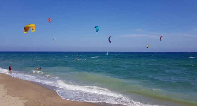 Spiaggia con i ragazzi che praticano kitesurf