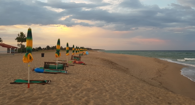 Ombrelloni e sdraio in fila sulla spiaggia